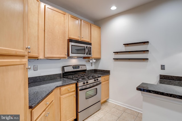 kitchen featuring dark stone countertops, stainless steel appliances, light brown cabinets, open shelves, and light tile patterned flooring