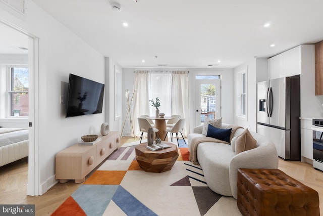 living area with light wood-type flooring, visible vents, and recessed lighting