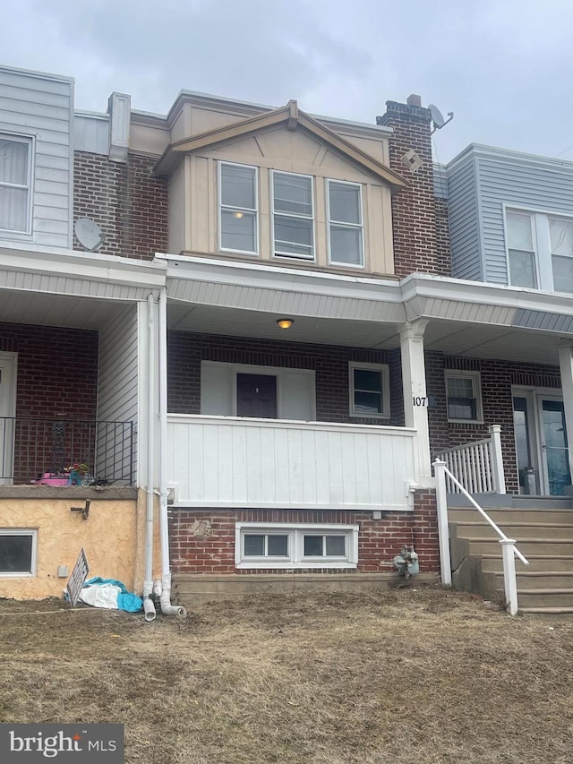 view of front of home with a porch and brick siding