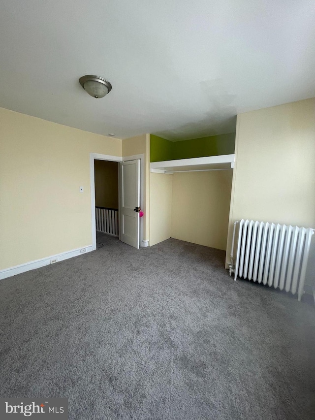 unfurnished bedroom featuring carpet floors, radiator heating unit, and a closet