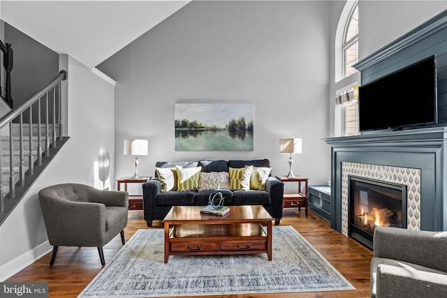 living room with a towering ceiling and hardwood / wood-style floors