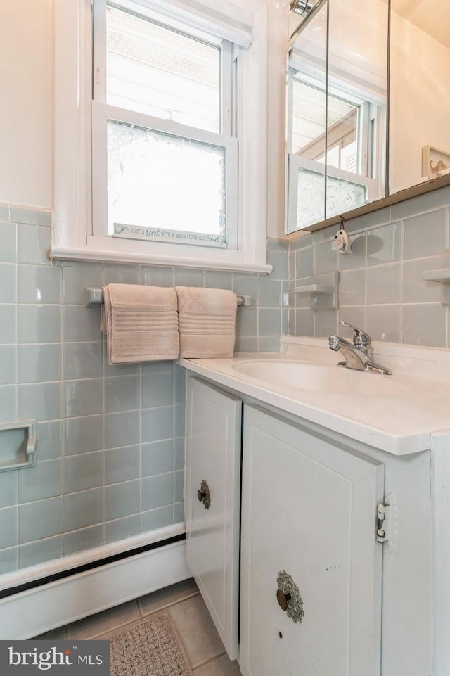 bathroom with plenty of natural light, baseboard heating, tile patterned flooring, and vanity