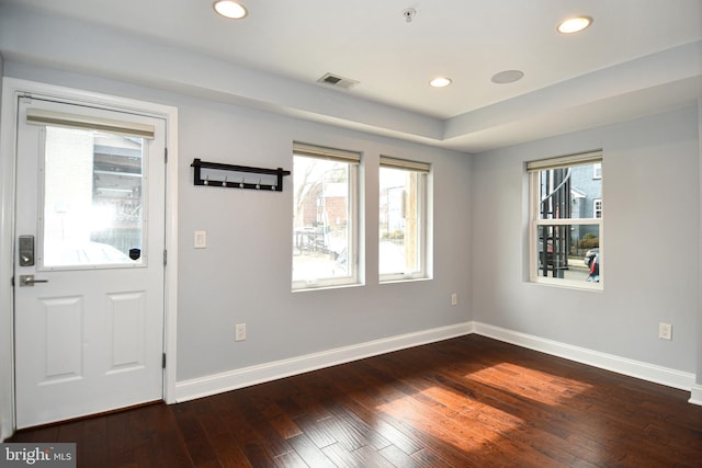 foyer entrance featuring baseboards, visible vents, dark wood-style flooring, and recessed lighting