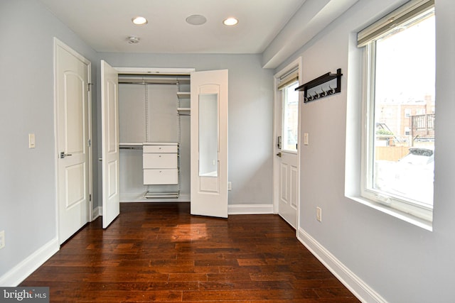 unfurnished bedroom with recessed lighting, a closet, dark wood finished floors, and baseboards