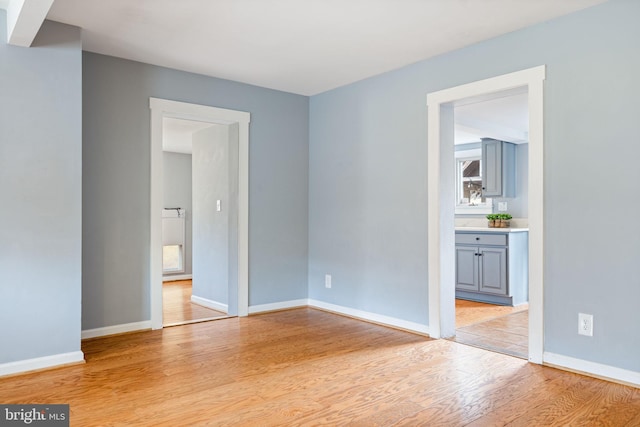 spare room with light wood-style floors and baseboards