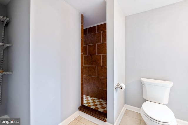 full bathroom featuring baseboards, a tile shower, toilet, and tile patterned floors