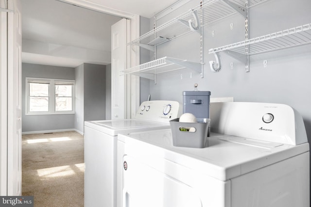 clothes washing area with carpet floors, laundry area, independent washer and dryer, and baseboards