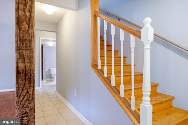 staircase with baseboards and tile patterned floors