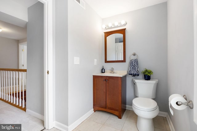 half bathroom featuring visible vents, toilet, vanity, tile patterned flooring, and baseboards