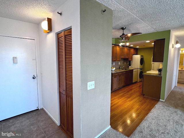 kitchen with sink, ceiling fan, backsplash, fridge, and a textured ceiling