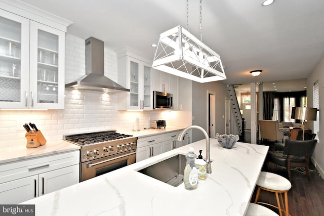 kitchen featuring white cabinetry, appliances with stainless steel finishes, and wall chimney exhaust hood