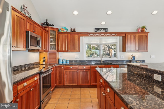 kitchen featuring light tile patterned floors, recessed lighting, a sink, appliances with stainless steel finishes, and glass insert cabinets