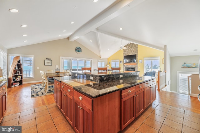 kitchen featuring vaulted ceiling with beams, light tile patterned floors, and a kitchen island