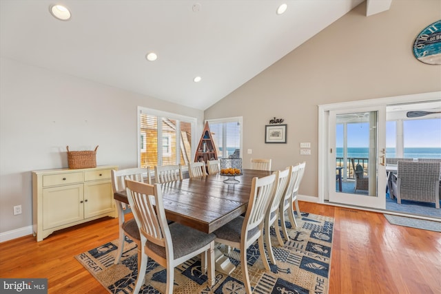 dining space with light wood-style floors, recessed lighting, high vaulted ceiling, and baseboards