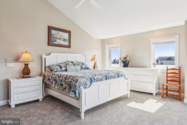 carpeted bedroom with ceiling fan, multiple windows, baseboards, and vaulted ceiling