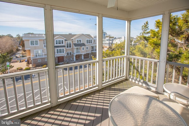 sunroom with plenty of natural light and a residential view