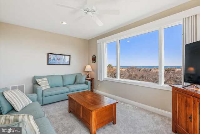 carpeted living area featuring a ceiling fan, visible vents, and baseboards