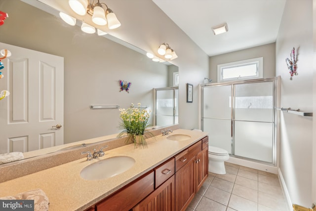 bathroom featuring double vanity, a shower stall, a sink, and tile patterned floors