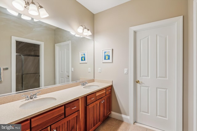 bathroom featuring double vanity, a sink, a shower with door, and tile patterned floors