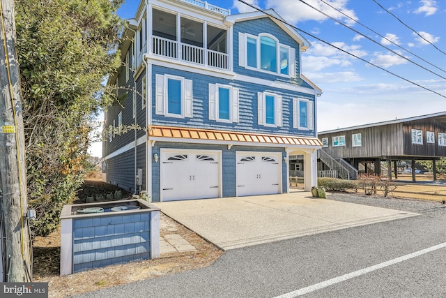 view of front facade with an attached garage, stairs, and concrete driveway