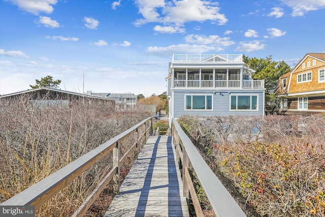 rear view of property with a balcony and a sunroom