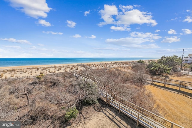 property view of water featuring a view of the beach and fence