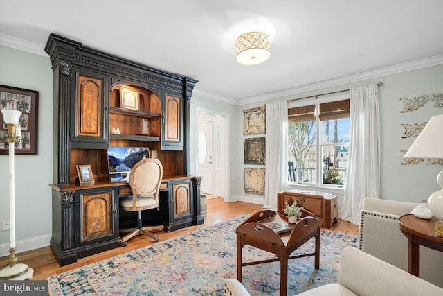 interior space featuring ornamental molding, light wood-type flooring, and built in desk