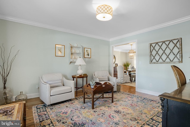 sitting room with crown molding, baseboards, and wood finished floors