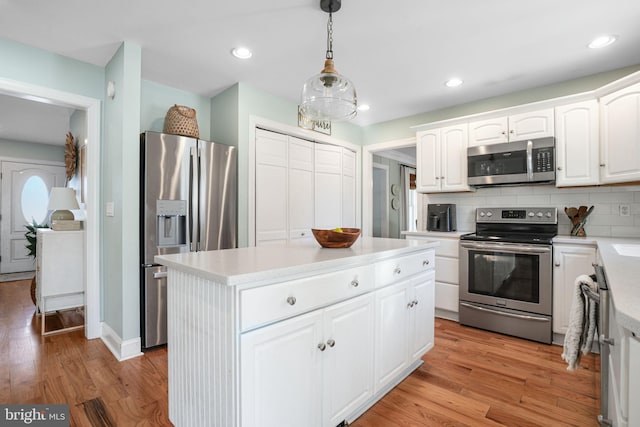 kitchen featuring stainless steel appliances, tasteful backsplash, a kitchen island, and light wood-style floors