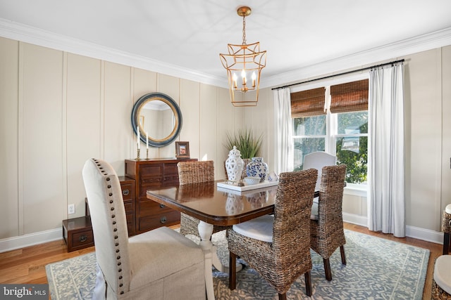 dining space with a chandelier, crown molding, baseboards, and light wood-style floors