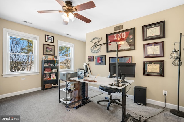 carpeted office space featuring visible vents, ceiling fan, and baseboards