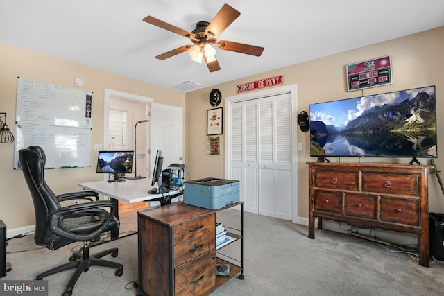 home office with light carpet, ceiling fan, and baseboards