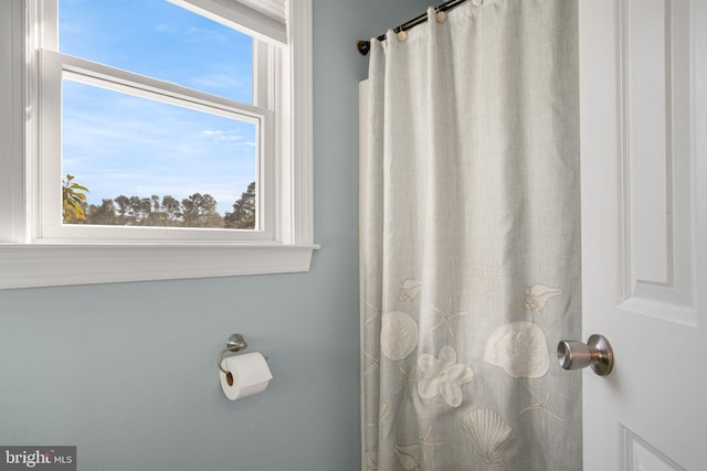 bathroom featuring a shower with shower curtain and a healthy amount of sunlight