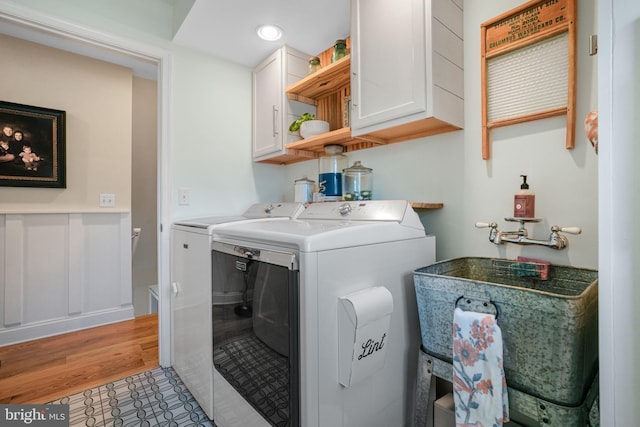 washroom with cabinet space and separate washer and dryer