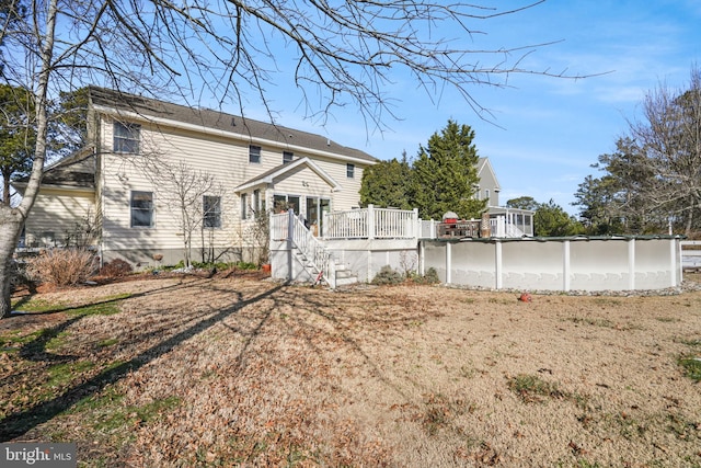 back of house featuring stairway, a covered pool, and a deck