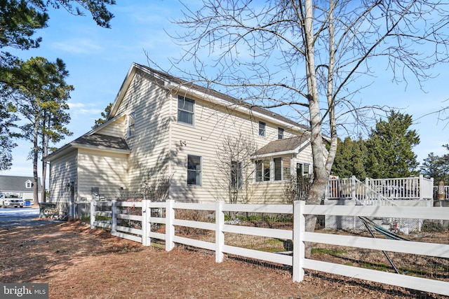 view of side of property with a deck and a fenced front yard