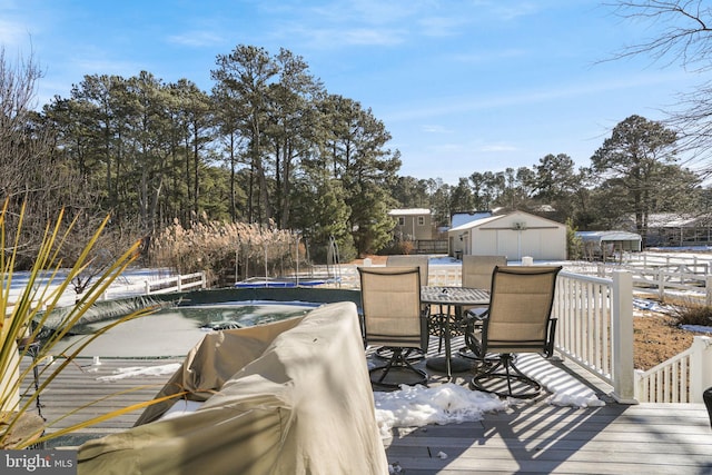 wooden deck with an outbuilding, outdoor dining area, and a swimming pool