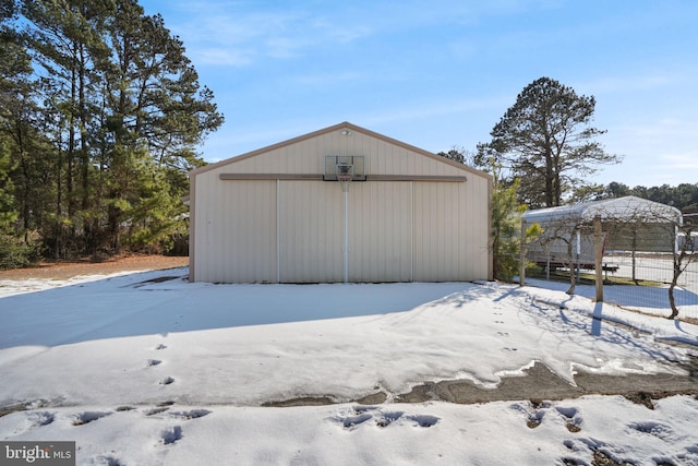 snow covered structure with an outbuilding