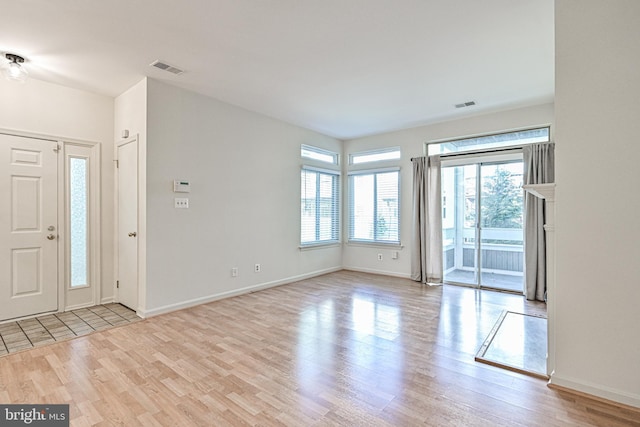 foyer entrance featuring light wood-type flooring, baseboards, and visible vents