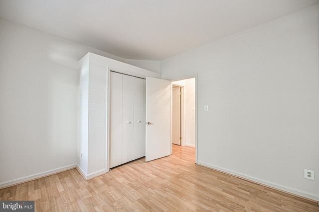 unfurnished bedroom featuring light wood-style floors, a closet, and baseboards