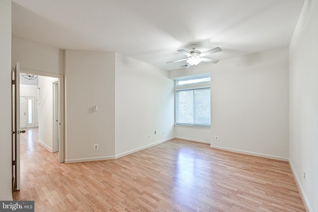 empty room featuring light wood-type flooring, baseboards, and a ceiling fan