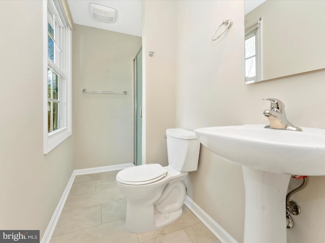 bathroom featuring a shower stall, toilet, baseboards, and tile patterned floors