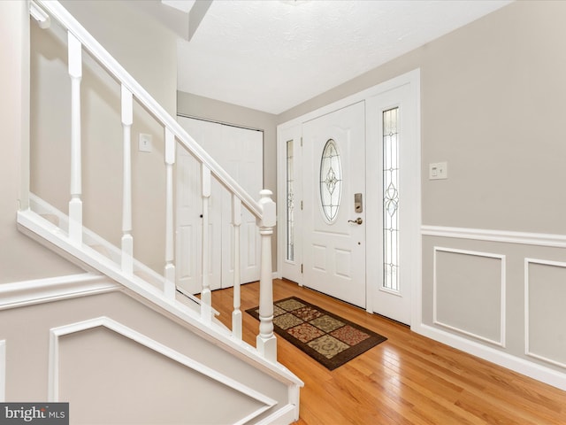 foyer entrance with wood finished floors and stairway