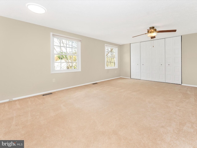 unfurnished bedroom featuring visible vents, baseboards, and light colored carpet