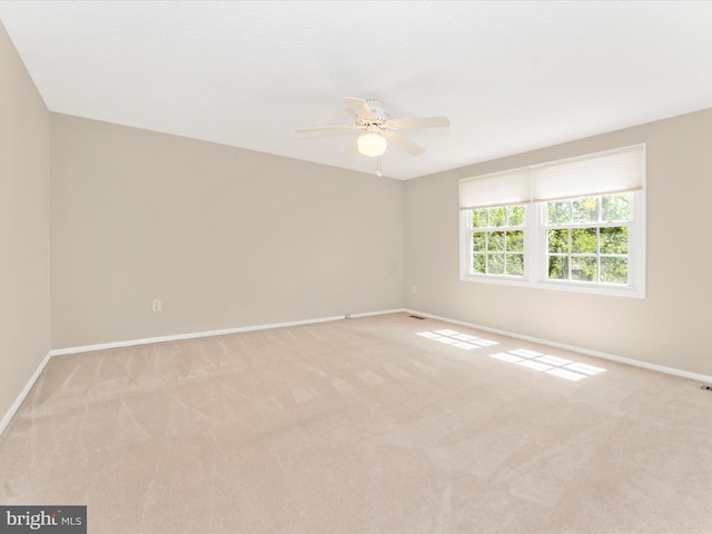 empty room featuring light carpet, baseboards, ceiling fan, and visible vents