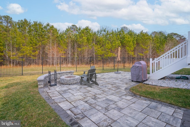 view of patio featuring a fenced backyard, a grill, and a fire pit