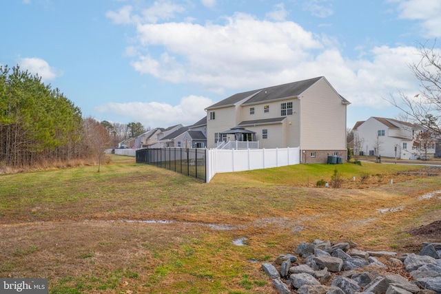 rear view of house with a residential view, fence, cooling unit, and a yard