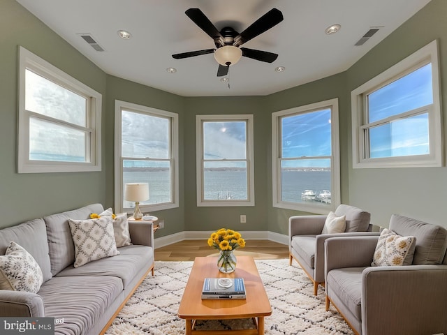 living room featuring baseboards, light wood-style flooring, visible vents, and recessed lighting