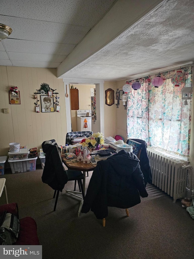 carpeted dining space featuring washer / dryer, a textured ceiling, and radiator heating unit