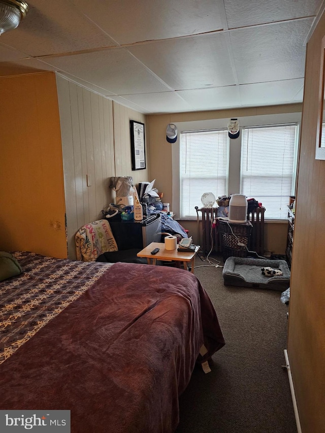 carpeted bedroom with wood walls